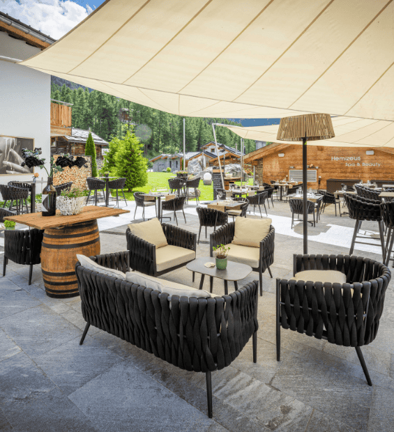 Lounge-Bereich auf der Gartenterrasse des Restaurant Genepy Zermatt mit Aussicht